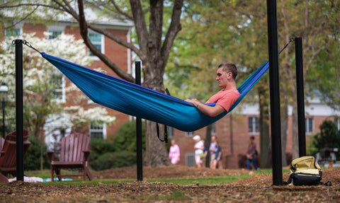 A student hammocks in Elon University's hammock station. 