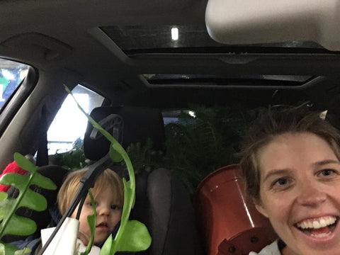 Suzanne met planten en zoon in de auto