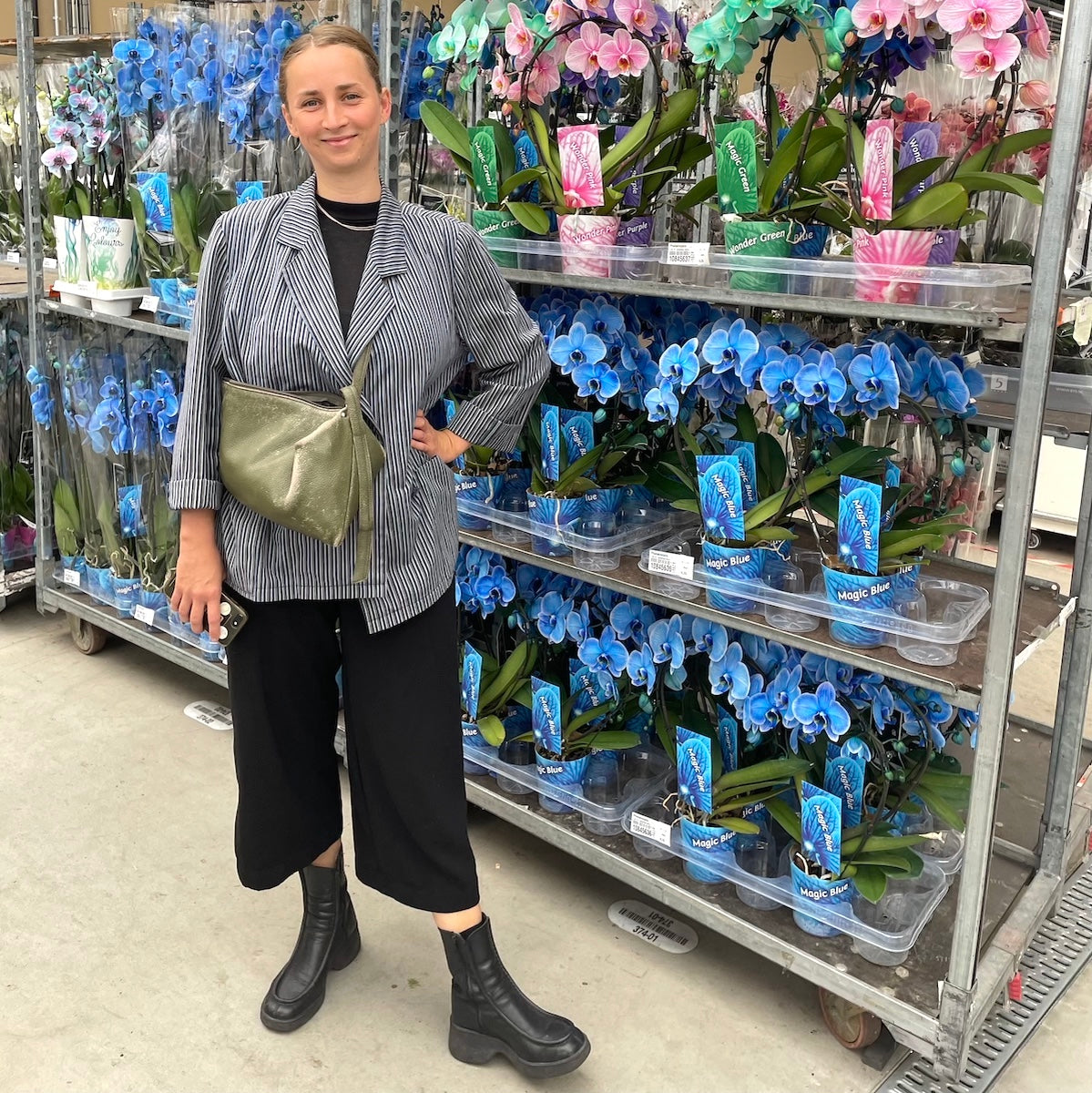 vrouw staat voor kar met blauwe orchideen