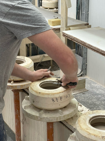 Clay factory worker finishing a mold. Hands are still involved in every step of the process