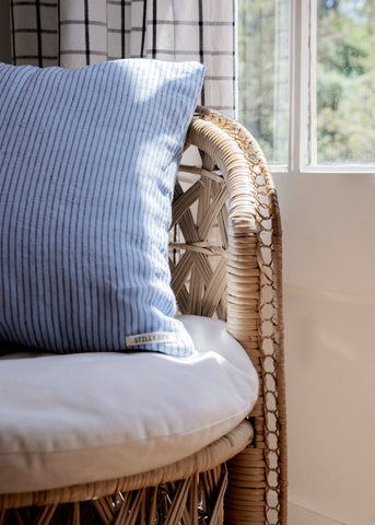 Stilleben Cushion Cover in Celestial Blue/Navy Stripe in a rattan chair