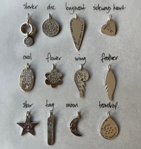 Examples of each silver shapes available for LifeStory charms. 12 shapes laid out in 3 rows of 4. Left to right, top row: starter (chunky silver bale for charms), disc, longheart and sideways heart. Middle row: oval, flower, wing, feather. Bottom row: star, tag, moon, teardrop. Most charms are stamped with lettering and patterns.