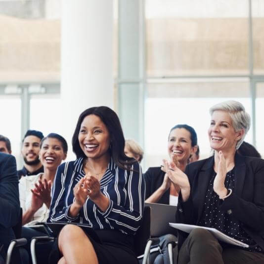 people clapping at event and smiling