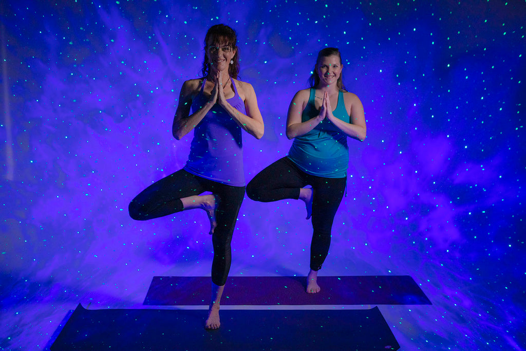 women doing yoga with galaxy lights