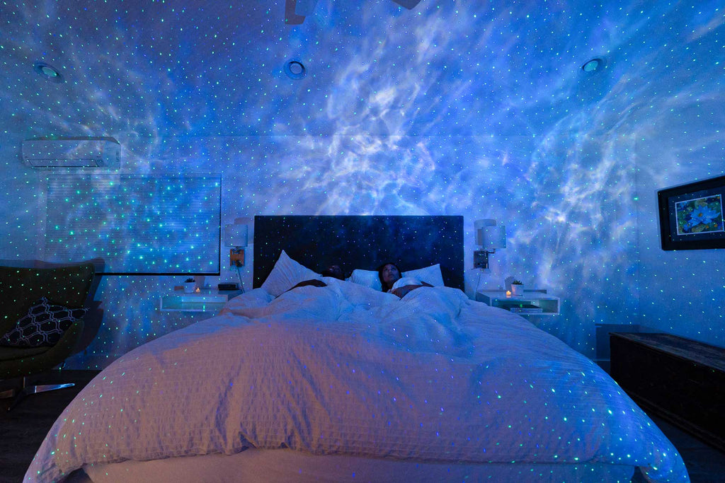 three sky lite evolve galaxy projectors shining cyan in bedroom
