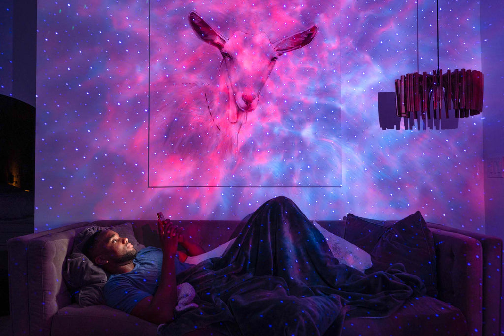 man reclining under sky lite evolve multicolor galaxy projector in pink