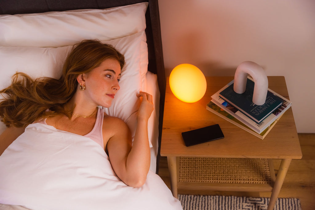 woman in bed next to blissradia smart ambient light