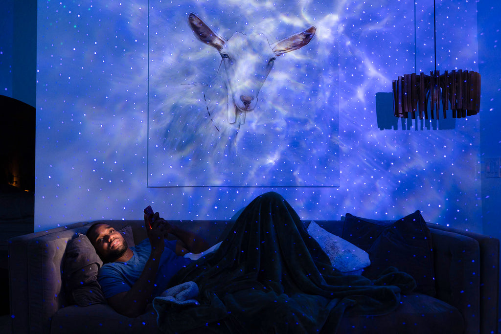 man lying on couch with blue galaxy lighting