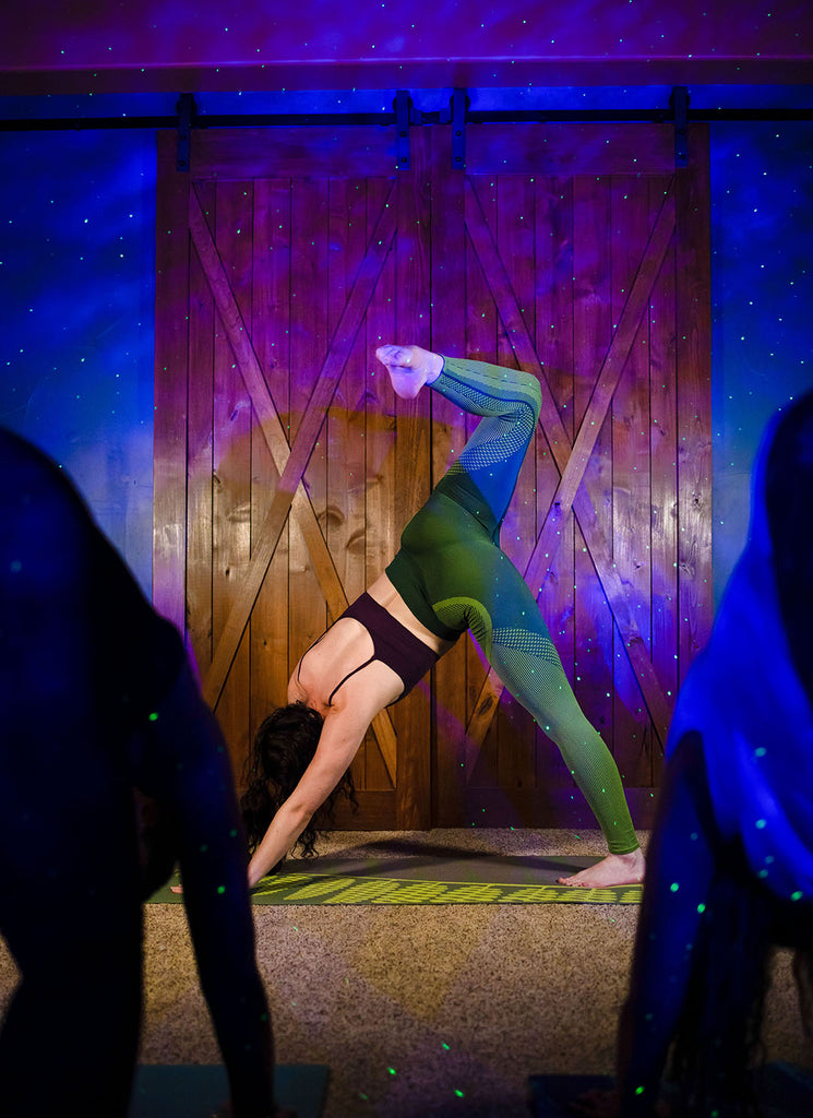 woman doing yoga with sky lite galaxy projector