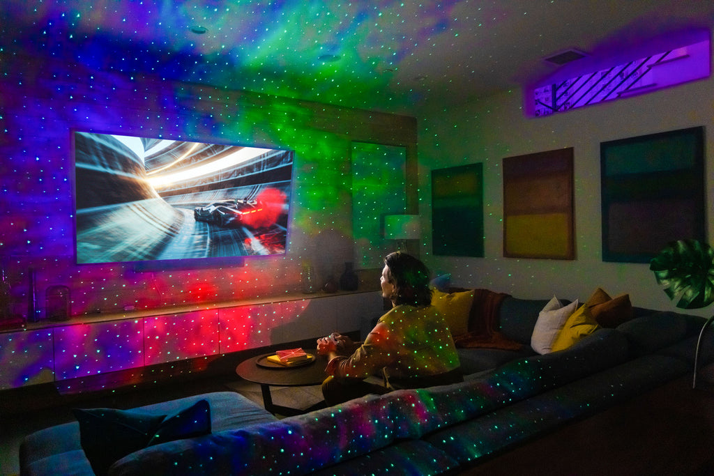 man playing video games in living room with multicolor galaxy lighting