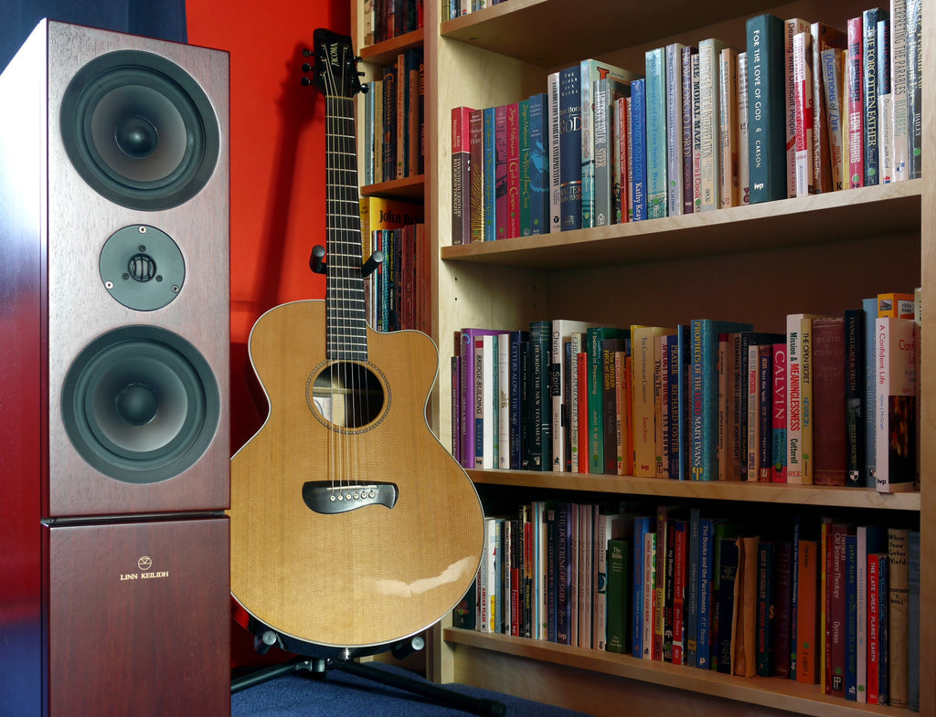 speakers next to guitar in music room