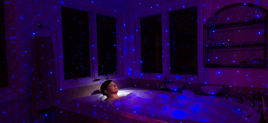 woman in bathtub with blue laser lights