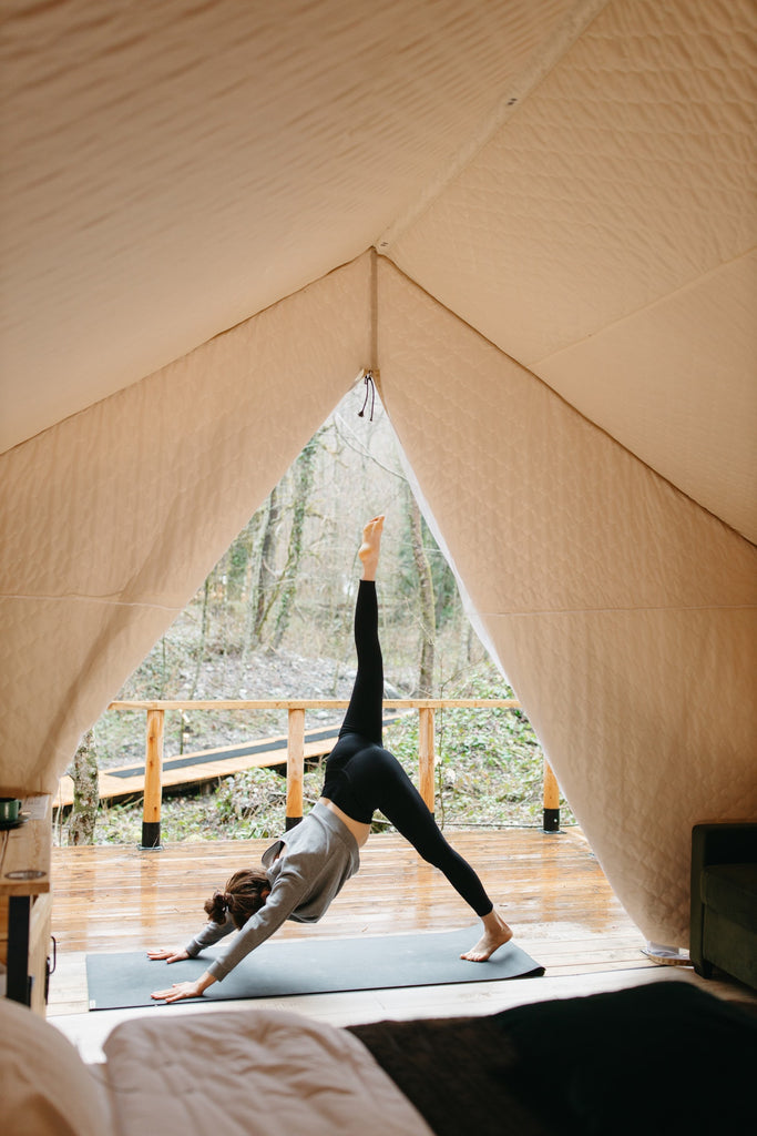 woman doing yoga in glamping tent