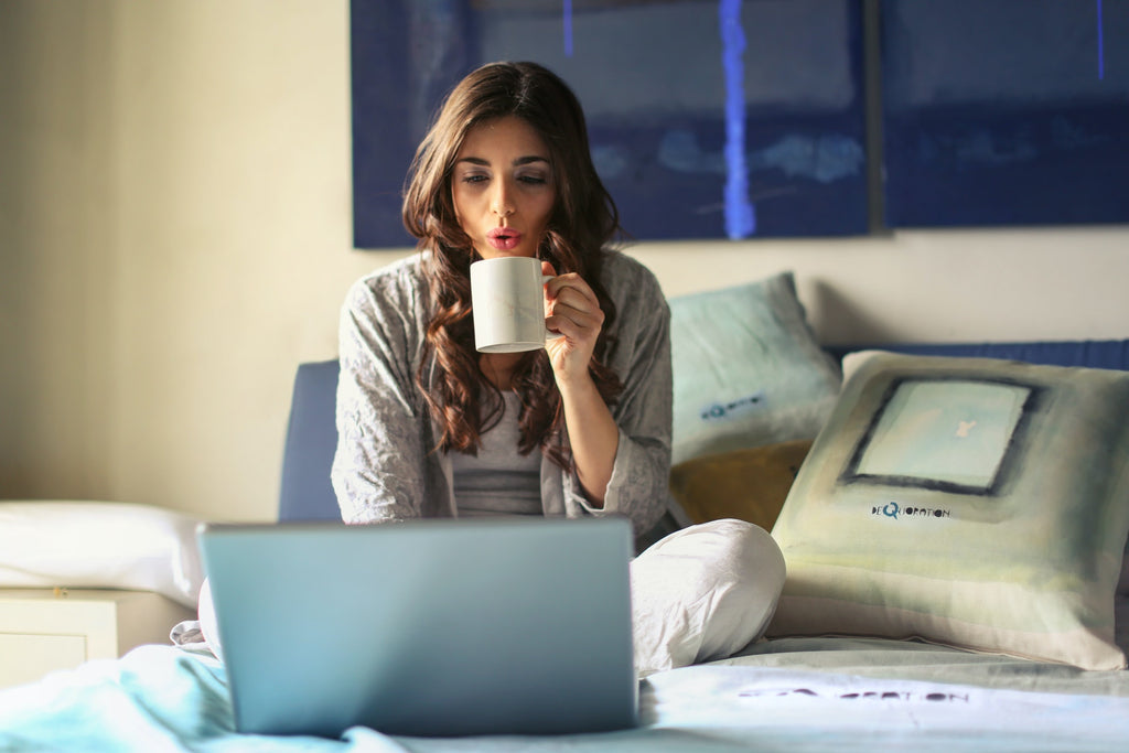 young woman drinking coffee and streaming on laptop