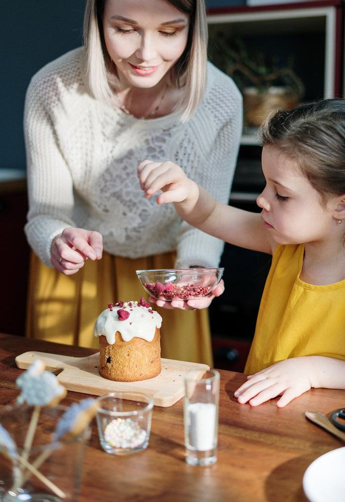 mom and child decorating cupcake