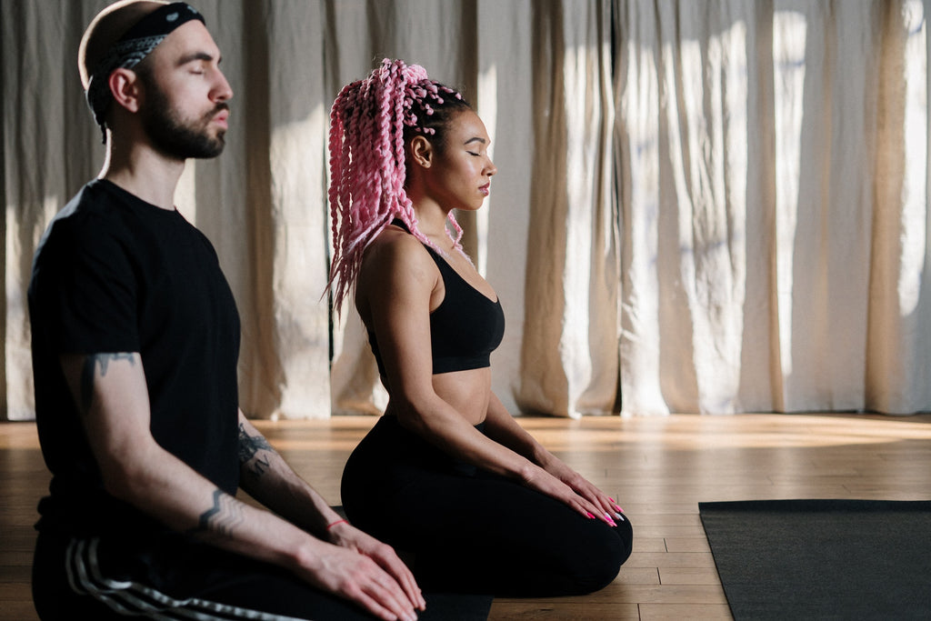 man and woman meditating