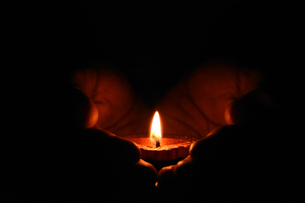 hands holding a lit candle