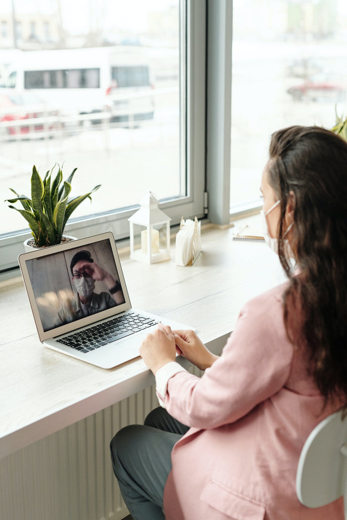 woman sitting across from window during virtual meeting