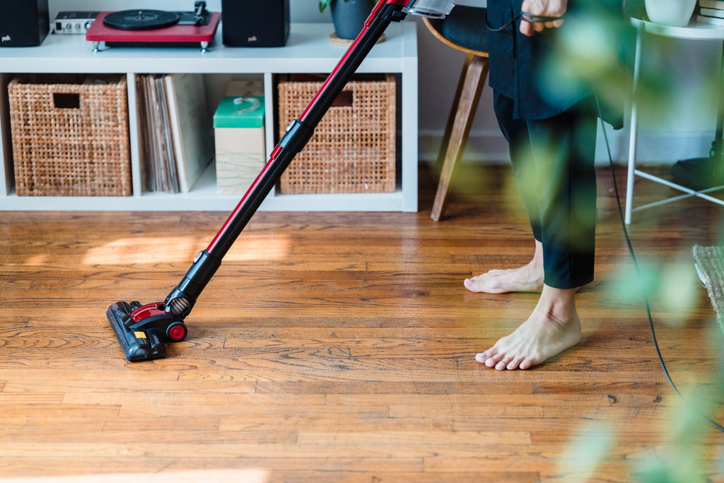 woman tidying room with vacuum