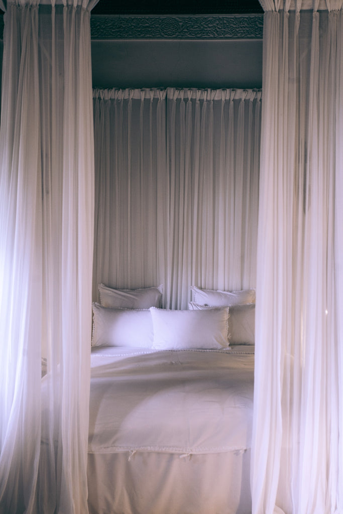 canopy bed with sheer white curtains