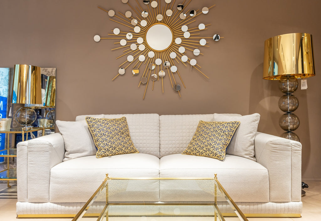white couch with gold decor accents and designer floor lamp
