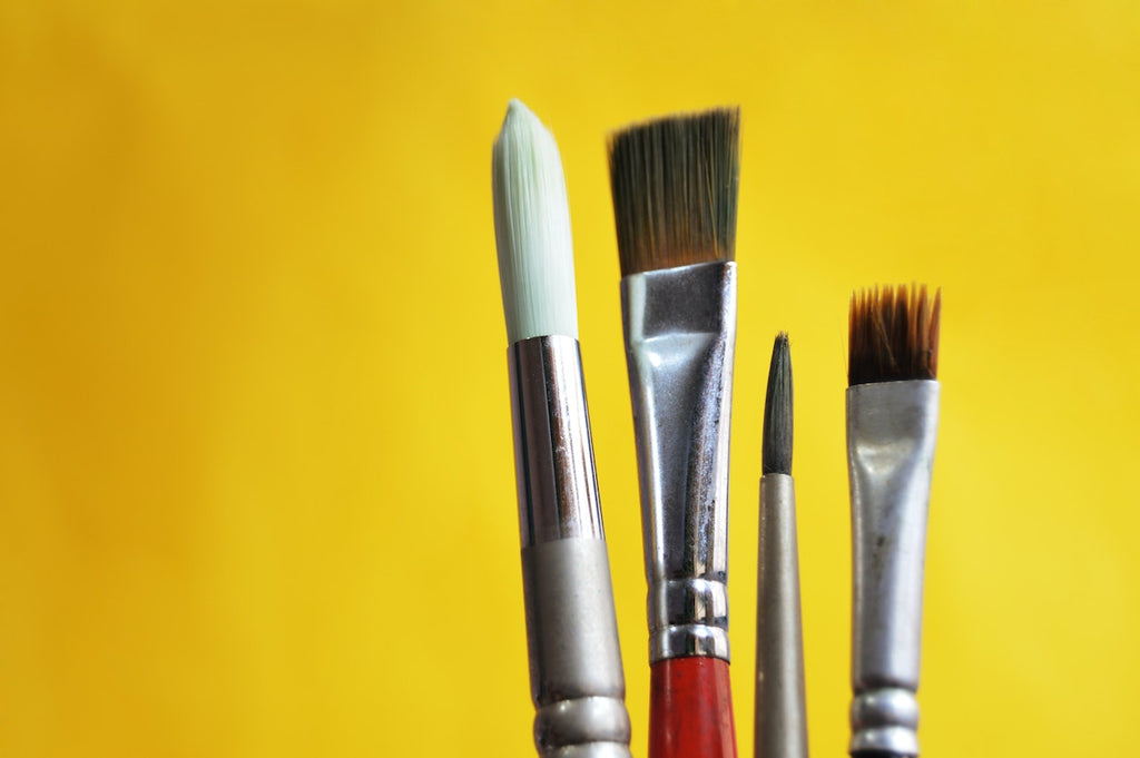 paintbrushes on yellow background