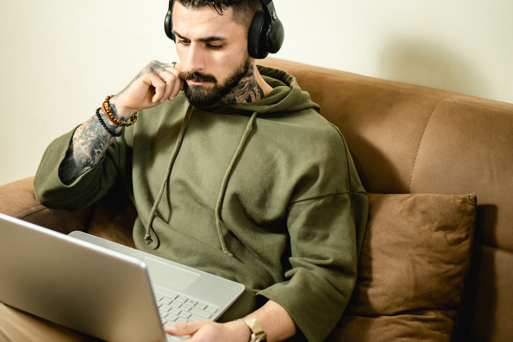 man in green hoodie wearing black wireless headphones
