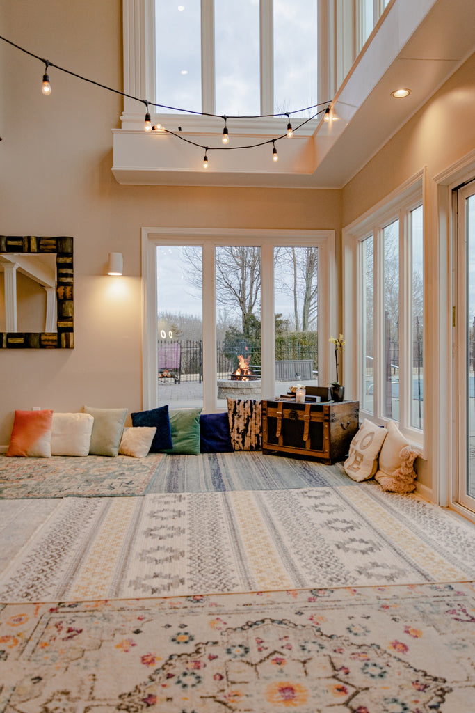 room with floor pillows and patterned rugs