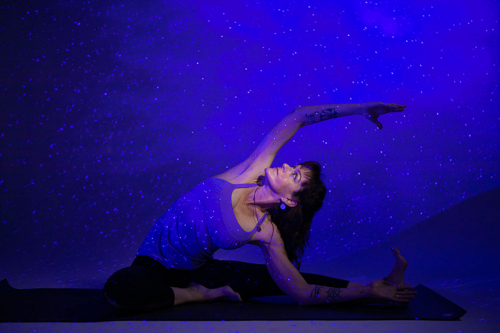 woman doing yoga with galaxy lighting