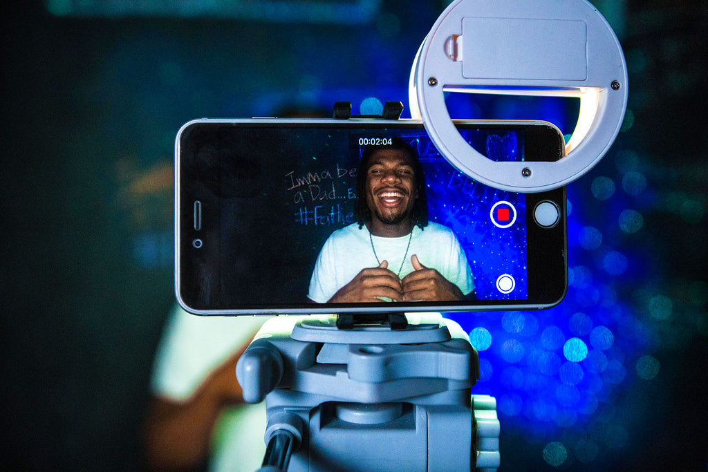 man recording himself in front of a colorful backdrop