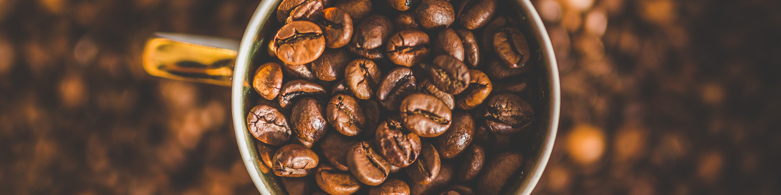 Grains de café dans une tasse à café et dispersés sur la table