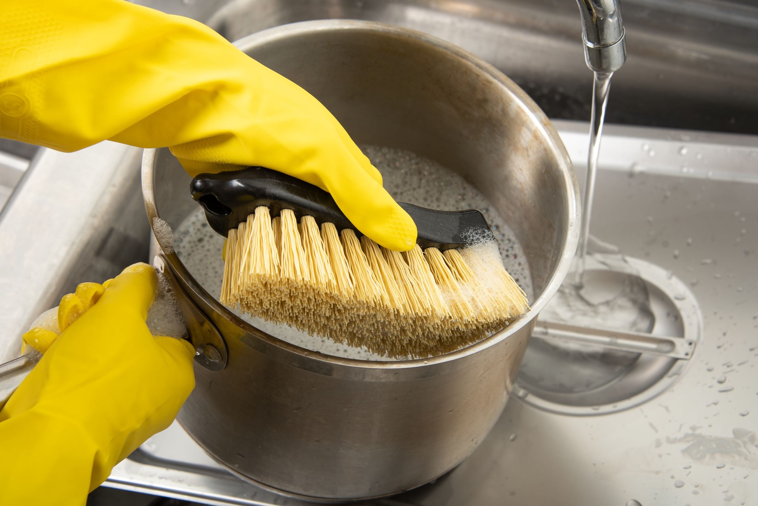 Nettoyer la vaisselle avec une brosse et de l'eau et du savon
