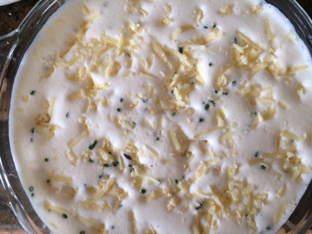 Gently pour 2 cups of egg/milk mixture over cheese. Repeat process of blending second batch of egg and milk mixture, then gently pour over eggs. 