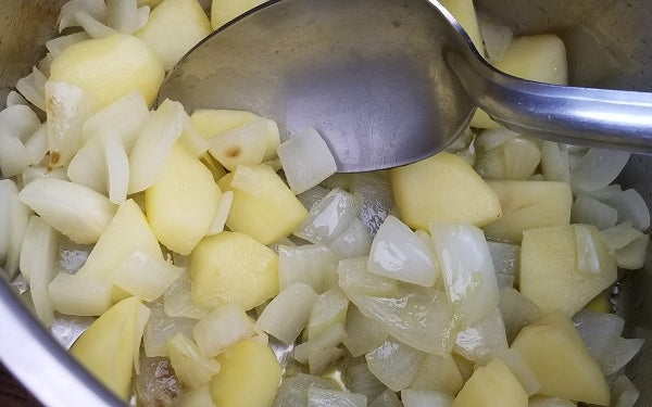 Chop up the onion and apple. Coat a large soup pot with olive oil, add onion and apple, then cook until the apple is soft and onion begins to brown, 8 to 10 minutes.