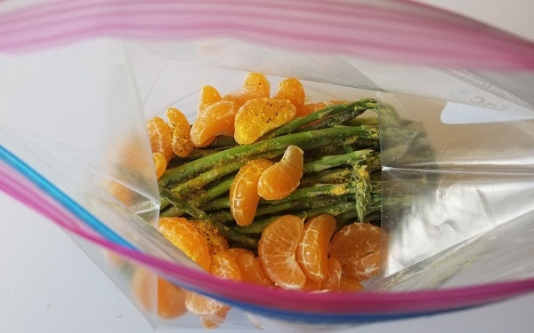 Place asparagus, tangerine segments, olive oil, lemon pepper and salt in a large sealable plastic freezer bag and shake until evenly coated.