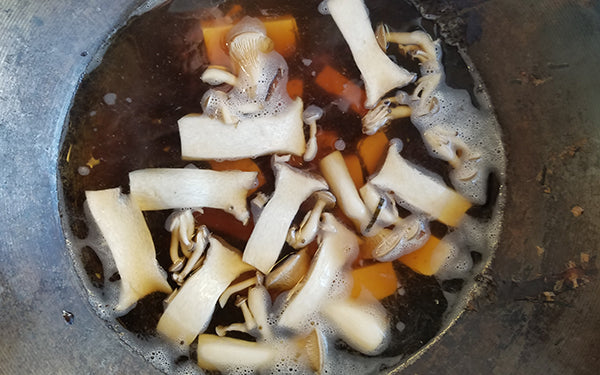 Place dashi stock back into wok and bring up to a simmer, then add tofu and mushrooms. Heat until mushrooms are soft.