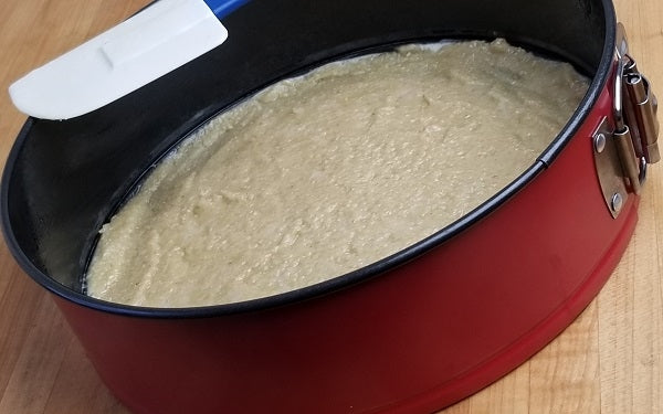 Spread macadamia mixture over the bottom of a greased cheesecake pan, cover with waxed or parchment paper, then press down until evenly distributed. Set aside.