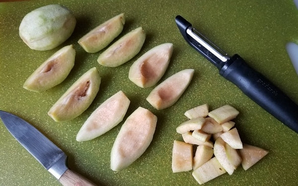 Using a vegetable peeler remove the feijoas’ skin and cut into quarters, then slice the fruit into smaller pieces.