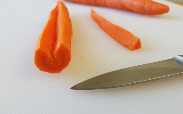 Use a paring knife to cut a V-shape notch all the way down the length of each carrot and remove the wedge created. Then hand the carrots over to your kitchen helpers for peeling and shaping.