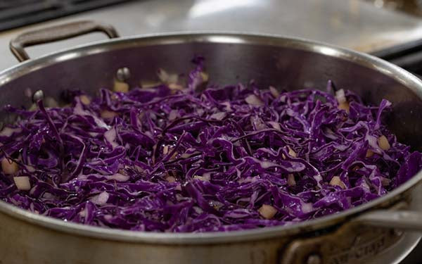 Add the cabbage, toss well. Drizzle the vinegar over the cabbage, cover and simmer for about 5 minutes. Toss well.