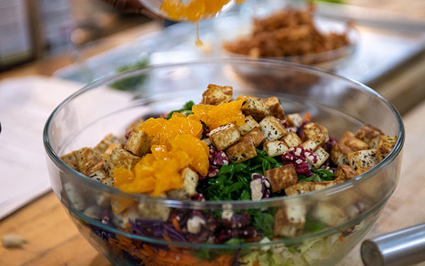 To assemble the salad, in a large bowl combine the cabbage, radicchio, carrots, green onions, walnuts, pan-fried tofu, and Ojai pixie tangerines, and toss together. Pour the dressing over the salad. Add the won ton strips and toss to combine. Garnish with the cilantro and sesame seeds.