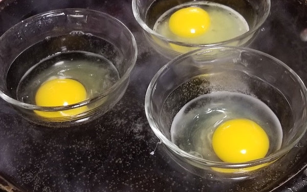 To poach the eggs, fill a large saucepan with water, about 1 1/2 inches deep. Bring water to a boil, then reduce to a simmer. Add white vinegar. One at a time crack the eggs into a ramekin and tip egg into water. Cook 3 minutes. Remove and place on a plate lined with paper towels to absorb water.