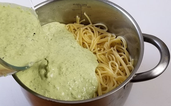 Image of adding sauce to spaghetti noodles