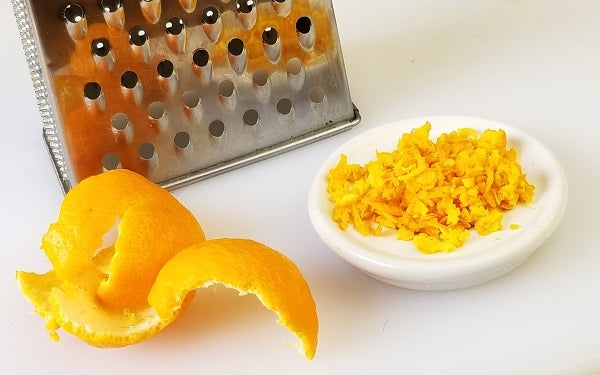 Using a box grater, zest all the peel from the two tangerines above, set aside. 