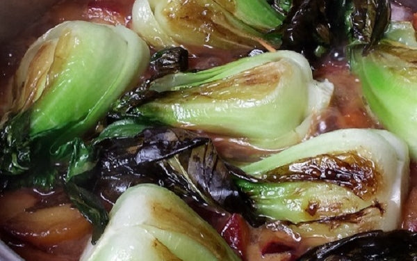 Add all of the bok choy back into the pan, set heat to medium-low, cover the pan and cook the bok choy in the plum sauce for 5 minutes.