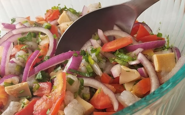 Add in the red onion, tomatoes, both peppers, and half the cilantro to the abalone and shrimp bowl. 