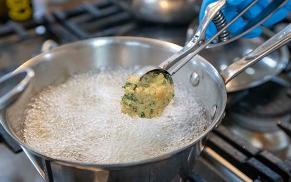 Pour vegetable oil into a heavy bottom, medium sized stock pot and heat the oil until a drop of the batter into the oil sizzles, about 3-4 minutes. 