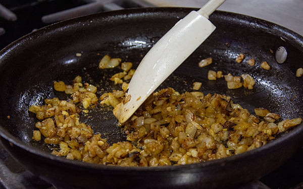 Heat oil in nonstick sauté pan over medium-high heat. Add onion and sauté for about 4 minutes or until soft and just beginning to brown. Add garlic and seasonings and simmer, stirring, for about one minute or until fragrant. Do not brown garlic. Set aside to cool.