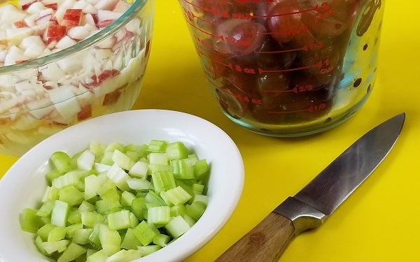 While gelatin is chilling, slice the grapes in half, dice both the celery and apple [keep diced apple in small bowl of lemon water until ready to use to avoid browning]