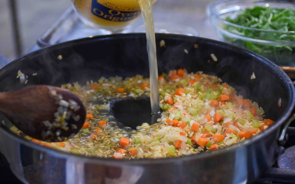 Carefully pour in 2 cups of the broth and bring to a boil. Reduce the heat to medium-low and simmer until the liquid is absorbed, stirring frequently.